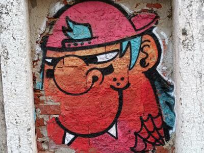 Personnage rouge au chapeau dans une niche — Street art à Almada
