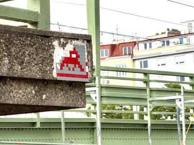 WN_26, Space Invader on Freda-Meissner-Blau-Promenade 1 — Street art by Invader in Wien