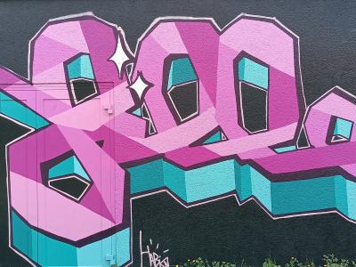 Lettrage géométrique rose sur noir — Street art à Sainte-Luce-sur-Loire