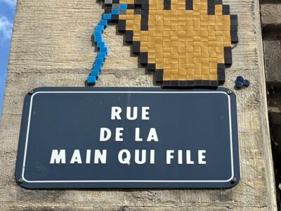 The Hand Spinning Its Blue Thread — Street art by Mifamosa in Orléans