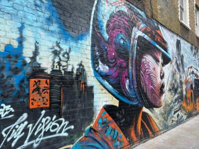 Pilote casquée devant la ville — Street art de Jim Vision à London