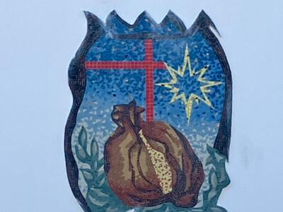 Blason en mosaïque à la croix et au sac — Street art à Le Croisic