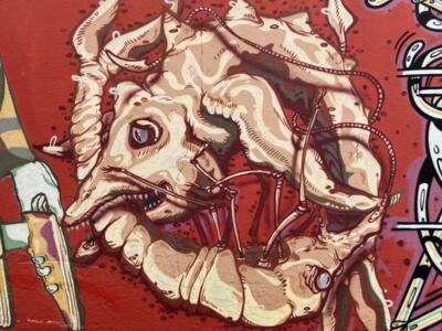 Horned creature curled around itself — Street art by HNRX in La Chaux-de-Fonds