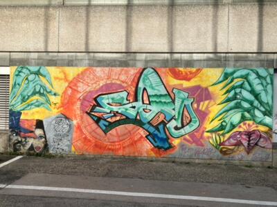 Mint lettering on an orange sun — Street art in La Chaux-de-Fonds