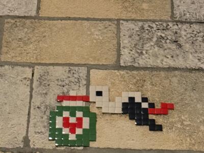 Stork carrying a heart bundle — Street art by Stork Pixelart in Biarritz