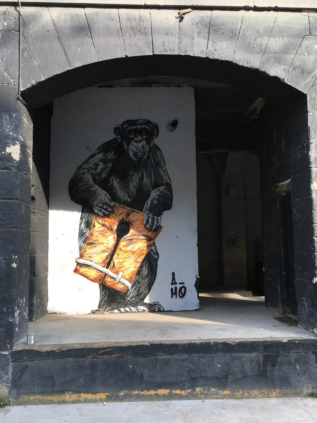 The lumberjack monkey, in an archway of the northern buildings.