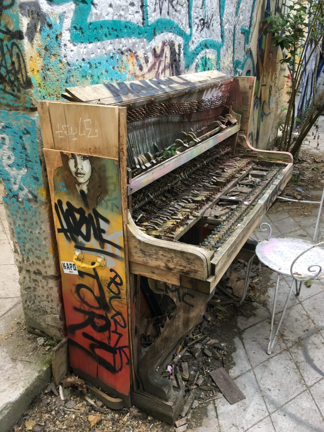 A tagged abandoned piano, left in a courtyard of the southern building. The gutted instrument serves as a surface like any wall on site.